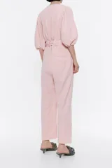 Mono largo color rosa de algodón, estilo cargo, largo tobillero, escote pico pronunciado, manga corta con volumen, elástico interior en puños y cierre con cremallera metálica frontal.