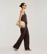 Pantalón de vestir de corte recto, color marrón oscuro con finas rayas verticales en tono más claro. Presenta un calce sastrero y bolsillos laterales.