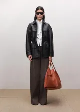 Camisa blanca de algodón con cuello clásico, manga larga y cierre frontal con botones ocultos.