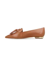 Zapato de cuero color caramelo, estilo mocasín con puntera fina y detalle de borla en el empeine. Cuenta con un tacón bajo con detalle metálico dorado.