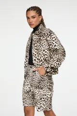 Chaqueta de denim de corte recto, con cuello camisero, cierre frontal con botones y bolsillos con solapa en el pecho, con estampado animal print.