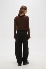 Pantalon de vestir negro de calce alto, con diseño barrel leg y pinzas frontales.