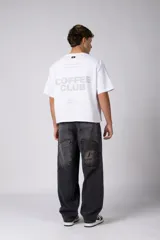 Jean de corte baggy y fit oversize, confeccionado en denim de algodón con lavado efecto gastado en color gris oscuro. Presenta costuras reforzadas en la zona de las rodillas y diseño de cinco bolsillos.