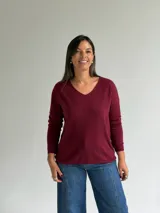 Sweater de punto en color bordó, con escote en V, mangas largas y diseño de corte recto con dobladillo ligeramente más largo en la parte posterior.