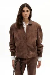 Chaqueta oversized de cuero de oveja color marrón antiguo, con hombros exagerados, cuello camisero redondeado, bolsillos frontales y botones a presión forrados. Cuenta con forro capitoneado y bolsillo interno.