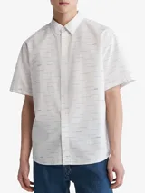 Camisa blanca de manga corta con estampado de líneas horizontales azules y logos de Calvin Klein.