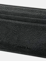 Tarjetero plano de piel granulada negra con seis ranuras para tarjetas y una ranura central. Presenta protección RFID y el logo de Calvin Klein grabado en la parte delantera.