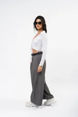 Pantalón de vestir gris de corte sastrero, con pinzas frontales, diseño de pierna ultra ancha y tiro medio.