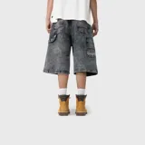 Bermuda baggy de denim color negro con efecto acid wash, corte amplio y diseño cargo. Cuenta con múltiples bolsillos utilitarios y trabillas para cinturón.