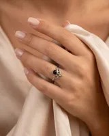Anillo de plata 925 con diseño de media luna y piedra central de ónix negro. Presenta detalles de pequeñas esferas metálicas en el contorno.