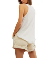 Musculosa blanca de lino y algodón, con escote redondo, cierre frontal parcial con botones, sisas bajas y costuras sin rematar con bordes deshilachados.