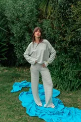 Conjunto de dos piezas de rib color blanco con finas rayas horizontales verde militar, compuesto por un buzo de manga larga de corte holgado y un pantalón largo de corte recto.