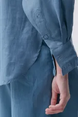 Camisa blanca de lino con cuello mao con volados, mangas largas y calce relajado.