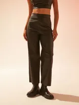 Pantalón negro de cuero sintético, corte recto y tiro alto.