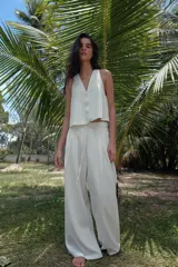 Pantalón ancho confeccionado en hilatura con lino, color blanco, de tiro alto con detalle de pinzas y lazada en la cintura.