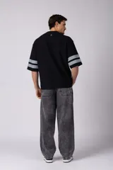 Remerón de corte oversize con cuello redondo y mangas cortas. Presenta un diseño estampado frontal con la palabra 'CONCEPT' y el número '78' en efecto desgastado, además de dos franjas horizontales en las mangas.