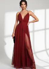 Vestido largo de tul color bordó con escote en V profundo, tirantes finos cruzados en la espalda y falda con doble tajo lateral.
