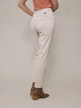Pantalón color beige de corte recto, con pinzas en la cintura, bolsillos laterales y tobillos ajustados.