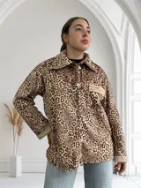 Sobrecamisa de pana color beige con estampado animal print, cuello camisero con solapa, cierre frontal con un botón, un bolsillo de parche en el pecho y puños y cuello con detalle de piel sintética.
