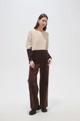 Sweater de punto con diseño color block, combinando beige en la parte superior y marrón en la parte inferior. Presenta cuello a la base, mangas largas y corte recto.