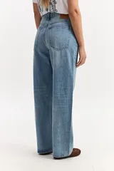 Jean baggy de tiro medio confeccionado en algodón, con diseño de piernas amplias, estilo slouchy y efecto gastado.