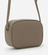 Cartera bandolera pequeña de diseño estructurado en color topo, con cierre de cremallera metálico y detalle de borla larga colgante. Cuenta con correa ajustable y forro interior.