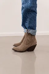 Bota corta de cuero vacuno color marrón topo, con diseño de estilo western, taco cuadrado de 7 cm y puntera metálica decorativa. Cuenta con cierre lateral interno para facilitar el calce.