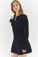 Vestido corto de punto acanalado en color azul marino, con escote redondo, tapeta de botones frontal, mangas largas, cuerpo entallado y falda con vuelo.