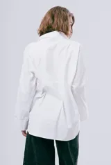 Camisa blanca de manga larga con cuello camisero, cierre frontal con botones y puños anchos.