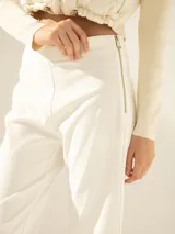 Pantalón blanco de tiro medio con cierre niquel lateral, tajos laterales en la bota, bolsillo ojal y pinza de entalle en la espalda.