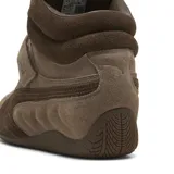 Championes Puma modelo Speedcat Wedge Wns, de caña alta y diseño con taco oculto, color marrón chocolate. Confeccionados en gamuza, incluyen cordones, tira de velcro con el logo grabado en el empeine y suela de goma inspirada en el automovilismo.