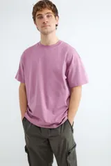 Camiseta de manga corta con corte relajado, confeccionada en algodón. Presenta un diseño básico y minimalista con cuello redondo.