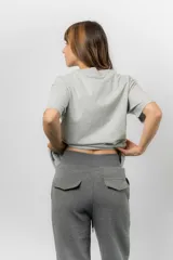 Pantalón blanco de silueta amplia y caída fluida, con cintura alta elastizada y lazo regulable con terminaciones metálicas.