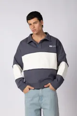 Buzo tipo polo de calce relajado con diseño de bloques de color en tonos marrón y blanco. Presenta cuello polo, cierre frontal parcial y logo estampado en el pecho. Confeccionado en tejido pesado con estructura.