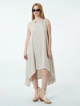 Vestido largo color beige con escote en V y cuello camisero. Tiene hilos metalizados en plata.