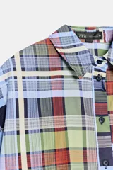 Camisa de manga corta de algodón, con cuello de solapa, cierre frontal de botones y bajo recto, con estampado de cuadros multicolores.