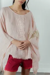 Blusa color rosa pálido de lino con mangas amplias y detalle de costuras en el frente.