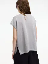 Chaleco de punto gris con escote en v y textura metalizada. Presenta mini tajos verticales en los laterales.