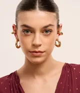 Set de accesorios compuesto por un par de aros tipo argolla y un par de ear cuffs, con diseño grueso y acabado en tono dorado.