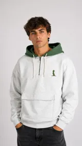 Hoodie de algodón gris jaspeado con cierre frontal parcial, capucha en color verde y bolsillo frontal tipo canguro. Presenta un pequeño bordado verde en el pecho.