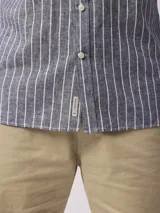 Camisa de hombre de manga larga con rayas verticales en tonos verde claro y blanco. Confeccionada en una mezcla de lino y algodón, presenta cuello abotonado y bolsillo en el pecho.