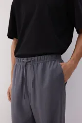 Pantalón gris de corte recto y relajado, con cintura elástica ajustable con cordón, bolsillos laterales y trasero. Confeccionado en mezcla de lino y viscosa.