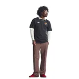 Remera de algodón negra con cuello redondo y mangas cortas. Presenta el logo del trébol de Adidas bordado en blanco en el lado derecho del pecho y un parche circular con los colores rasta en el lado izquierdo. Incluye un parche rectangular en la parte inferior con la inscripción Football is Freedom y una imagen de Bob Marley.