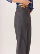 Pantalon de corte recto y tiro medio, confeccionado en tejido de lana con sutiles rayas verticales. Presenta bolsillos traseros aplicados, costuras reforzadas en las rodillas y ruedo con dobladillo.
