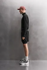 Short de running negro de tejido técnico perforado, ligero y elástico, con malla interior. Presenta cintura elástica ajustable con cordón interior, bolsillo trasero con cierre de seguridad y bajo con aberturas laterales.