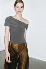 Body azul marino de escote asimétrico con un hombro descubierto, detalle de frunces en el busto y cierre de botones a presión en la parte inferior.