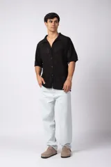 Camisa de manga corta tejida en algodón con diseño calado, cuello tipo bowling y cierre frontal con botones al tono.