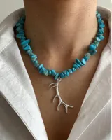 Collar corto de escallas de turquesa con dije colgante en forma de cuerno de acero y cierre de acero.