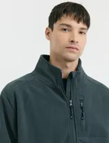 Campera de micropolar color verde oscuro, con cuello alto, cierre frontal completo, bolsillos laterales y un bolsillo con cierre en el pecho.