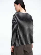 Buzo tejido de punto con diseño de rayas horizontales, cuello redondo y calce holgado con tajos laterales.